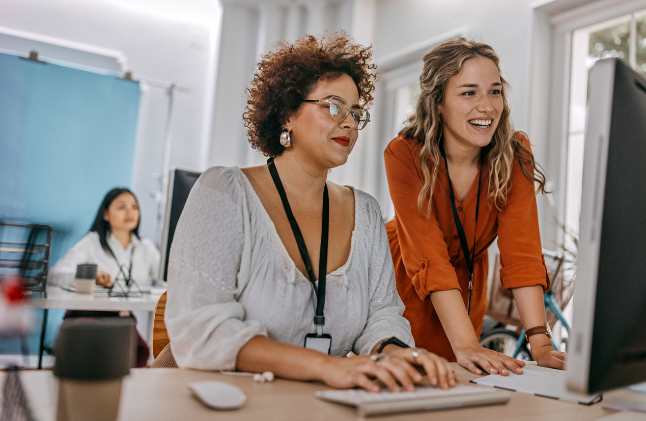 two-businesswomen-working-together-on-computer-at-office